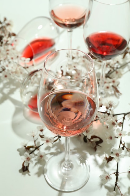 Verres de vin et fleurs de cerisier sur fond blanc