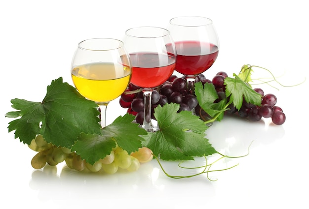 Verres de vin et de raisins mûrs avec des feuilles isolées sur blanc