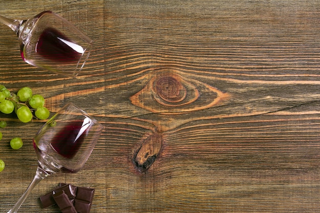 Verres de vin et raisins mûrs isolés sur une table en bois