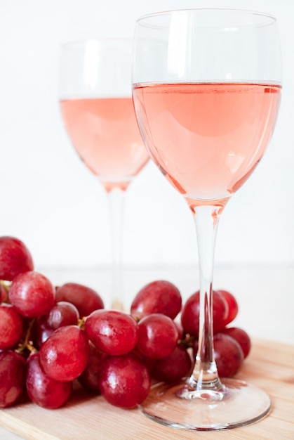 Verres de vin rosé et raisins rouges. deux verres de champagne.