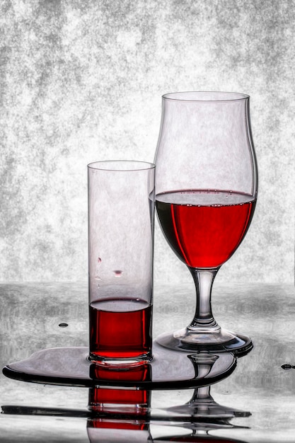 Des verres de vin rouge sur un fond noir et blanc