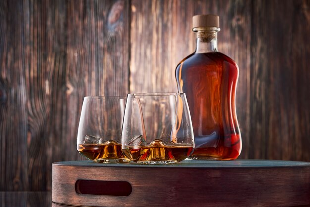 Verres de whisky et une bouteille sur la table en bois