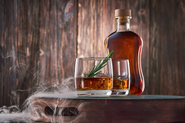 Verres de whisky et une bouteille sur la table en bois