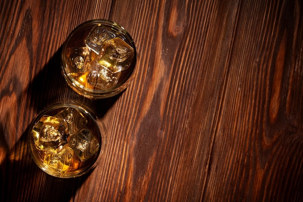 Verres de whisky avec de la glace sur bois