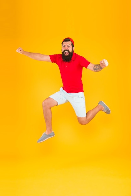 Vers le plaisir. Bénéficiant d'un mode de vie actif. Heureux gars sautant. Homme barbu actif en mouvement fond jaune. Hipster actif et énergique. Charge énergétique. Un mec en bonne santé se sent bien. Concept inspiré.