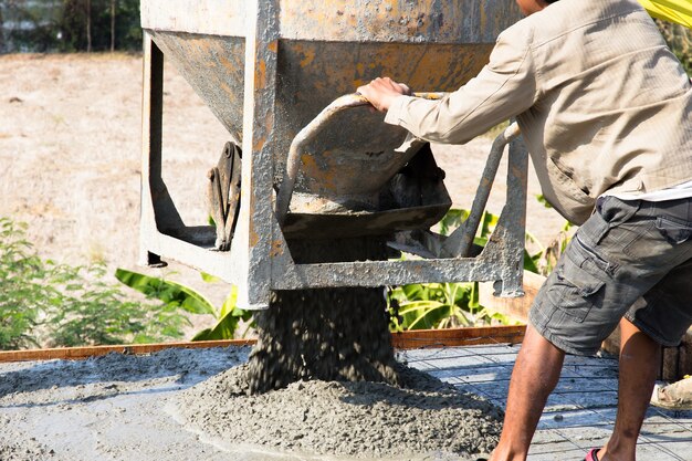 Verser le béton sur le sol à l&#39;aide d&#39;une grue avec un seau