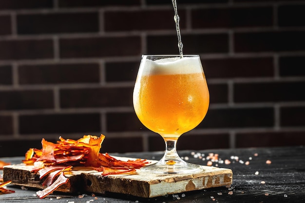 Verser la bière dans le verre avec une mousse épaisse de poisson séché Concept de brasserie de bière Snack pour la bière