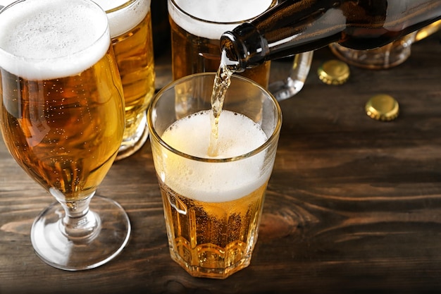 Verser de la bière dans un verre sur une table en bois