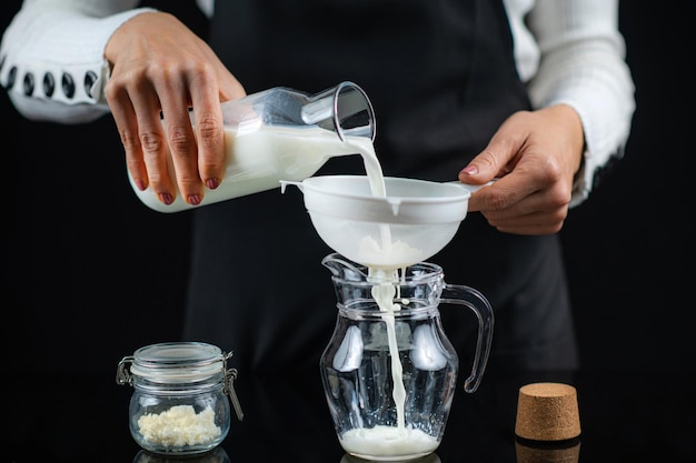 Verser du lait dans une tache avec des grains de kéfir Faire du kéfir à la maison