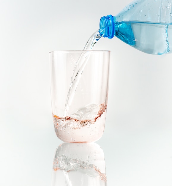 Verser de l'eau de la bouteille bleue dans le verre