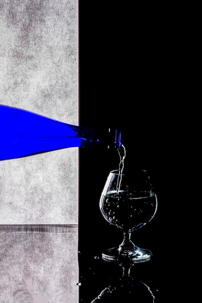 Verser le liquide d'une bouteille bleue dans un verre