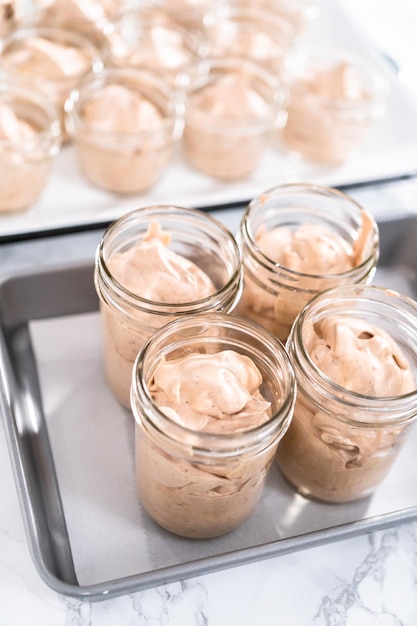 Verser le mélange dans les petits bocaux en verre pour faire de la glace au chocolat maison