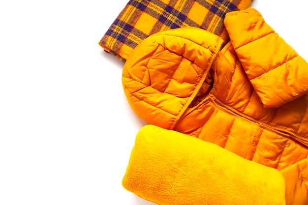 Veste jaune chaude et plaids doux en laine sur fond blanc. Tenue de mode. Couleurs vives. Stockage à domicile. Petit espace d'organisation.