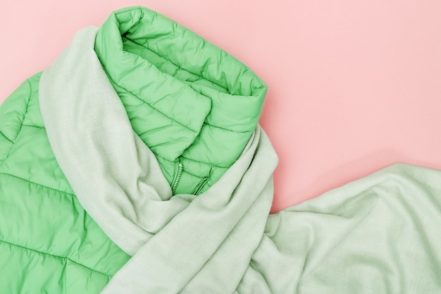 Veste verte et écharpe sur fond rose