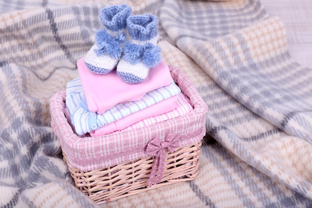 Photo des vêtements de bébé dans un panier en carreaux dans la chambre