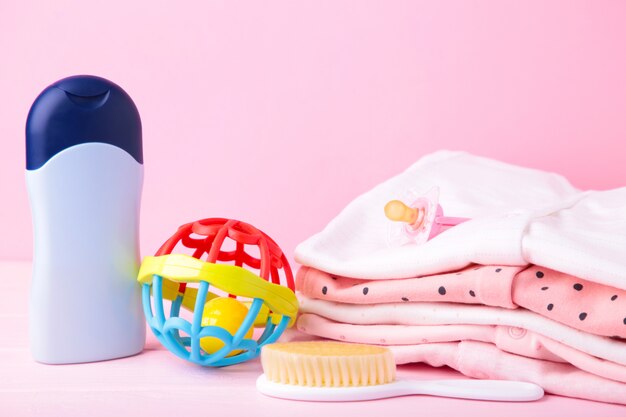 Vêtements bébé avec une douche accessoires sur fond rose