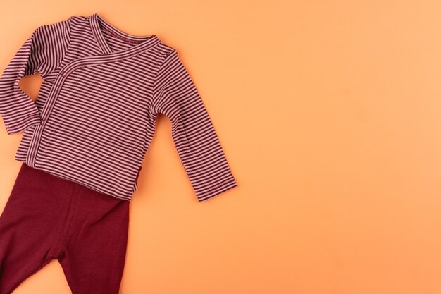 Vêtements de bébé fille sur la vue de dessus orange