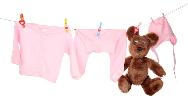 Vêtements bébé suspendu à une corde à linge isolé sur blanc