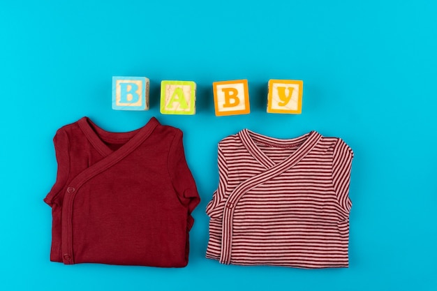 Vêtements de bébé sur la vue de dessus de fond bleu