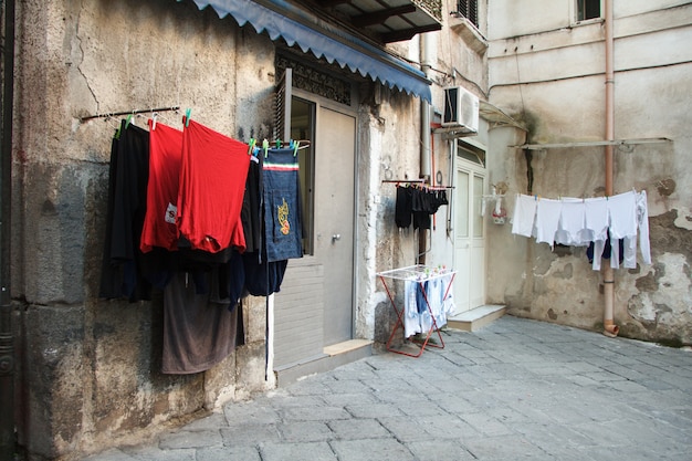 Des vêtements blanchis multicolores sont séchés sur le balcon de la ruelle de Naples