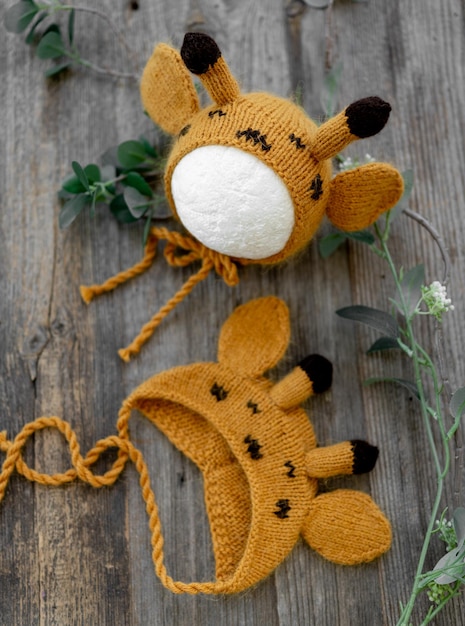 Vêtements de chapeaux pour nouveau-nés tricotés pour séance photo en studio pour bébés sur fond de bois en gros plan