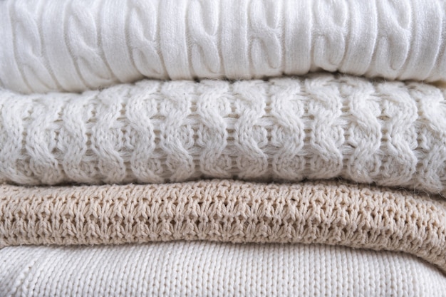 Vêtements chauds et confortables avec différents motifs tricotés en gros plan. Fond d'automne ou d'hiver.