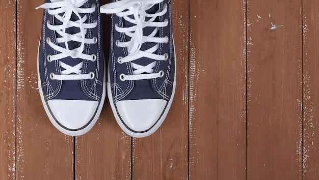 Vêtements chaussures et accessoires vue de dessus paire de fragments détective bleu fond en bois