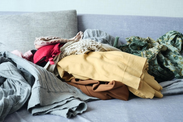 Photo vêtements en désordre sur le canapé à la maison