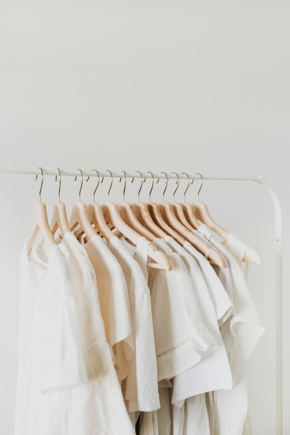 Vêtements féminins sur cintre. Composition de mode minimale sur blanc