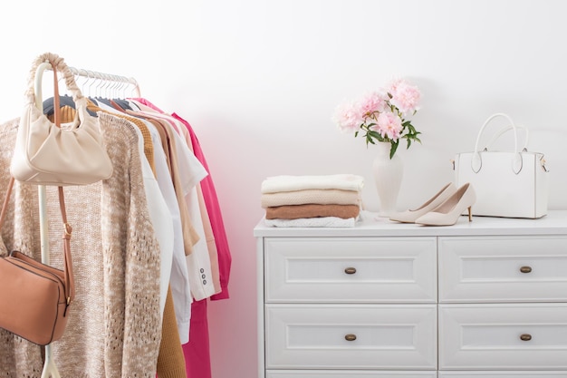 Vêtements féminins sur cintres en salle blanche