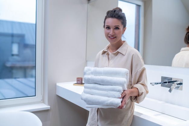 Vêtements frais. Une femme avec des vêtements propres dans les mains dans la salle de bain