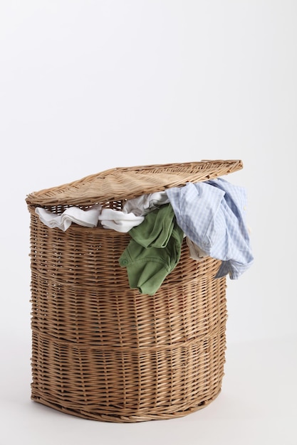 Photo vêtements en gros plan dans un panier en osier sur fond blanc