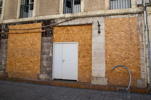 Photo les vêtements de mode high street shop ferment la vitrine du magasin protégé par une planche de bois après la fermeture et préparent sa rénovation pour la réouverture