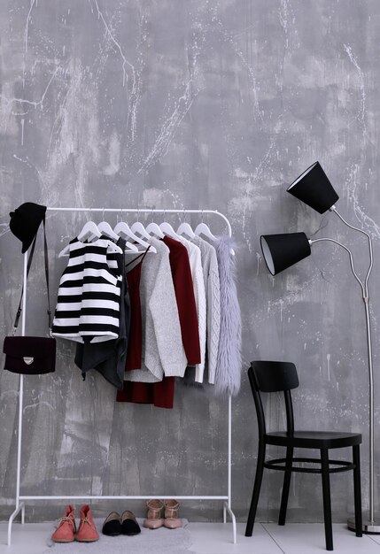Vêtements à la mode suspendus sur une étagère au dressing moderne