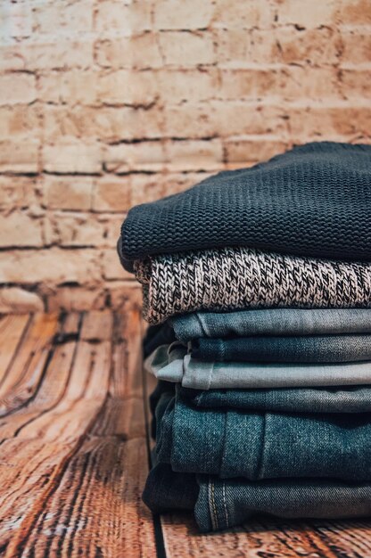 Vêtements à la mode. tas de jeans sur un fond en bois