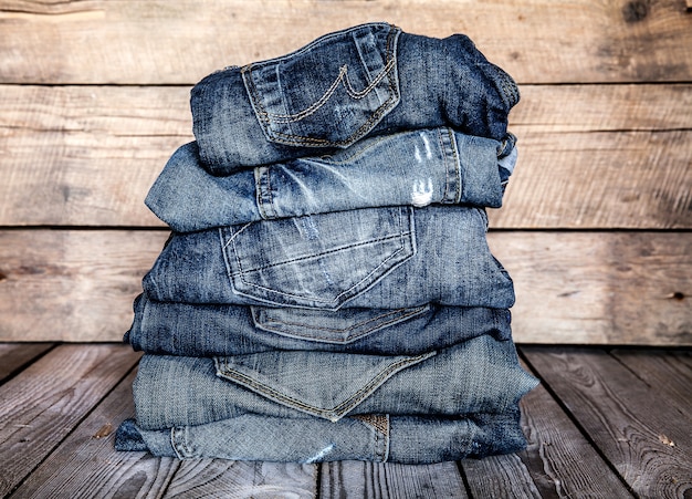 Vêtements à la mode. tas de jeans sur une table en bois