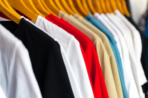 Des vêtements multicolores accrochés à un étagère dans un magasin