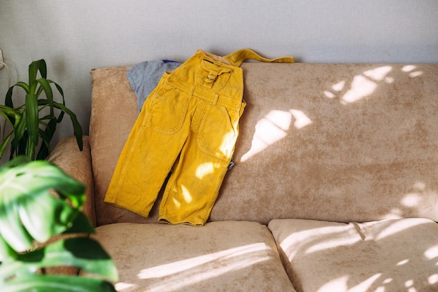 vêtements pour enfants combinaison jaune et tshirt allongé sur le canapé