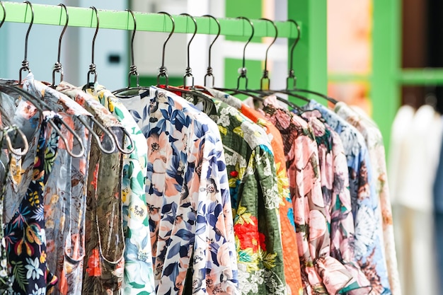 Les vêtements pour femmes à motif de fleurs colorées s'accrochent à la corde à linge verte dans la boutique de mode Asie Corée