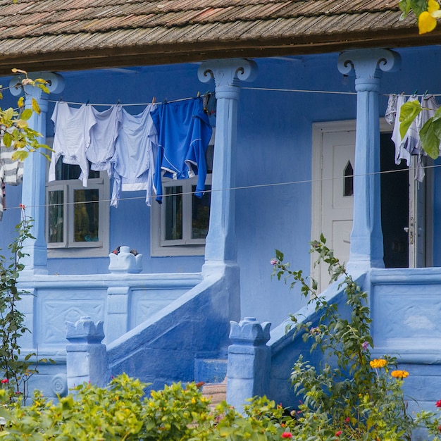 Des vêtements propres sont séchés dans la cour de la ferme bleue