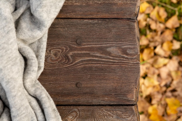 Vêtements tricotés sur banc en bois dans le parc d'automne chandail de laine chaud fond d'automne ou carte postale