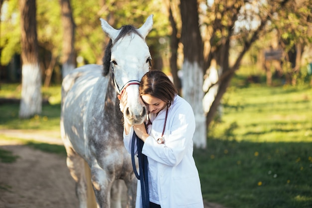 Vétérinaire profitant d'un cheval à l'extérieur au ranch.