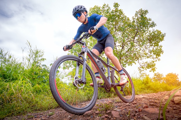 Les vététistes font du VTT, du VTT de descente à l'extrême. Un homme asiatique fait du VTT, du VTT à l'état sauvage jusqu'à l'extrême. Sport extrême et VTT, concept de vélo de montagne.