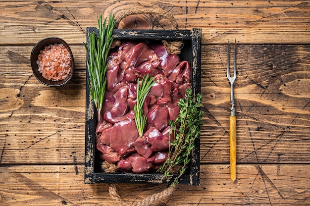 Viande d'abats de foie de poulet cru frais dans un plateau en bois