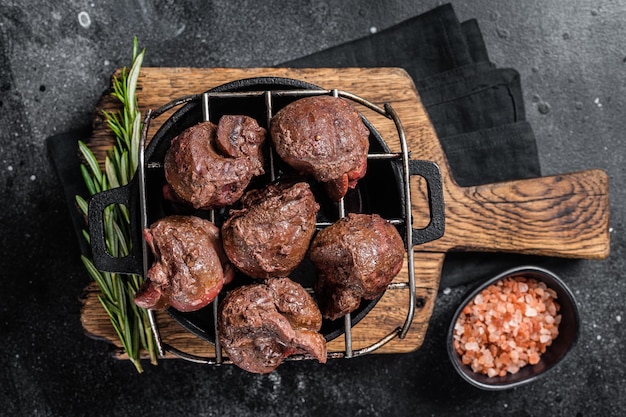 Viande d'abats de rein de veau de boeuf grillé sur le gril Fond noir Vue de dessus