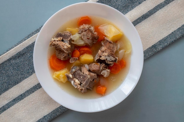 Viande d'agneau bouillie avec pommes de terre, carottes, oignons, vue de dessus, espace de copie. Nourriture réconfortante d'hiver faite maison.