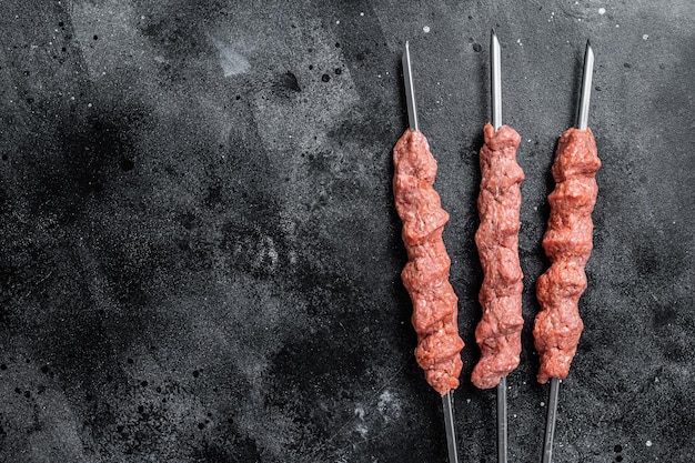 Viande d'agneau hachée crue shish kebab sur table de boucher Fond noir Vue de dessus Espace de copie