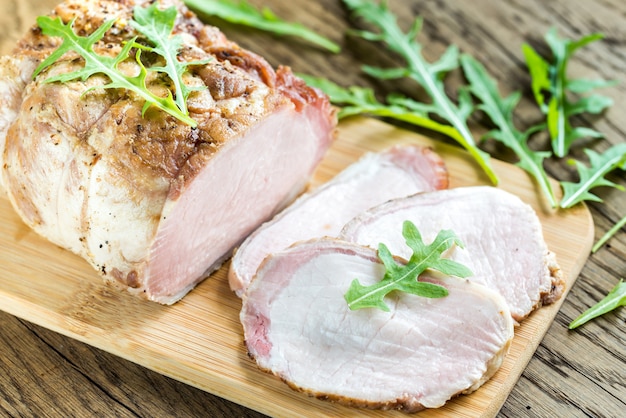 Viande au four avec salade de roquette fraîche sur la planche de bois