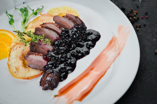 Viande au four avec sauce aux cerises et pomme. Vue de dessus. Espace libre pour votre texte.