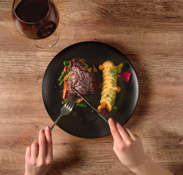 Viande Aux Légumes Et Garnir Sur Une Assiette Noire. Boeuf Aux Légumes. Délicieux Plat De Restaurant.